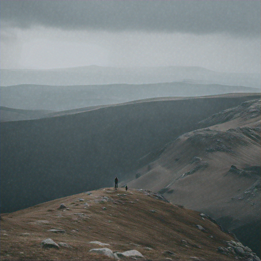 Lost in the Vastness: Two Figures Traverse a Desolate Mountain Range